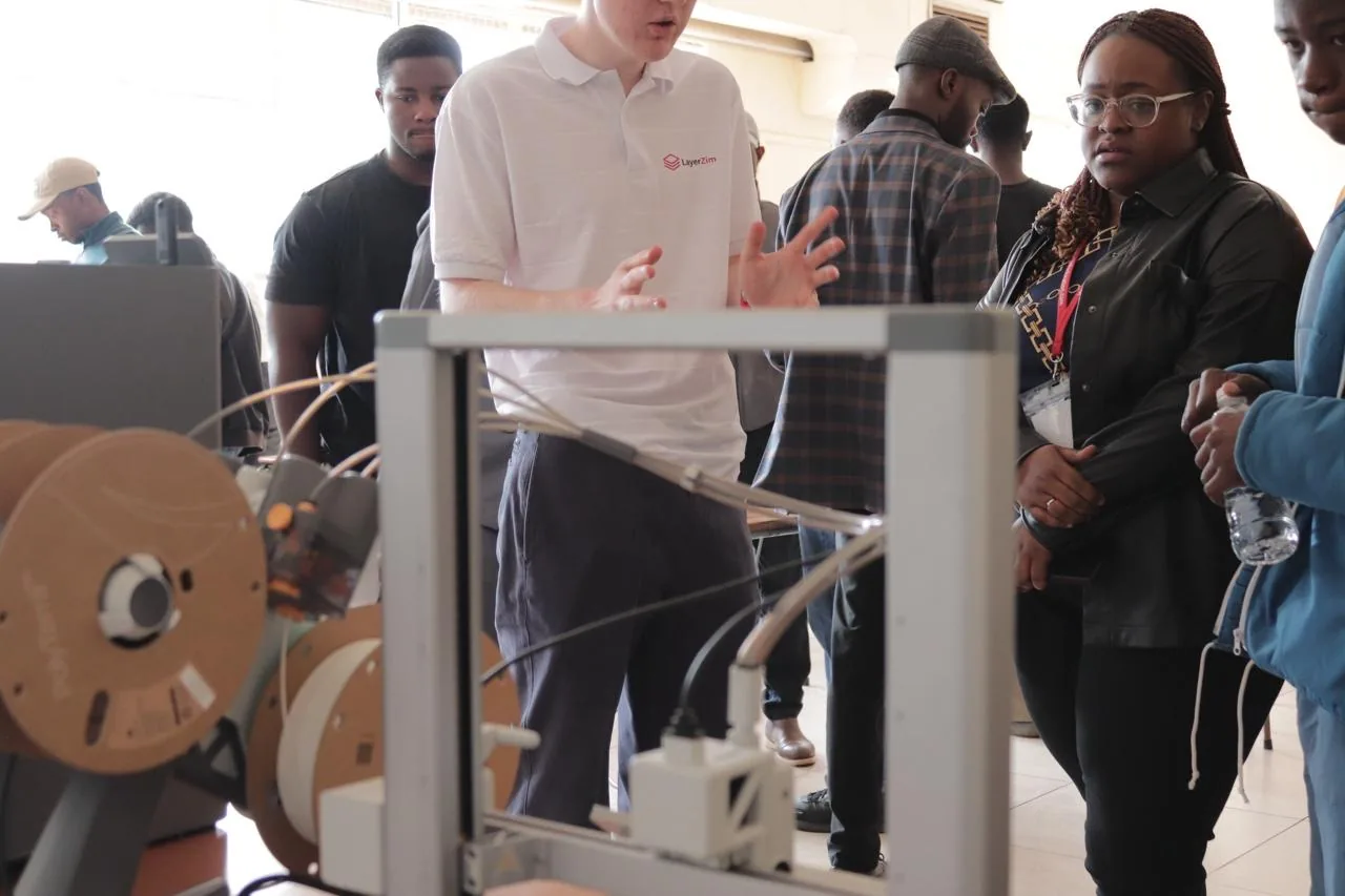 Layerzim demoing a 3D printer to workshop attendees in Harare